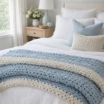 Soft blue crochet throw blanket on a calm white bedroom bed